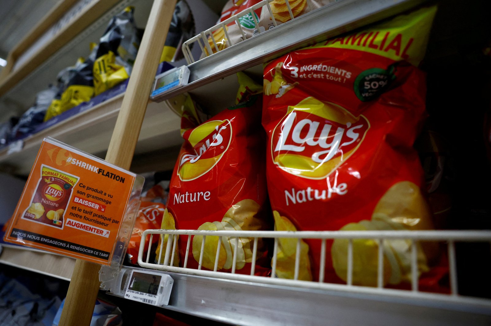 A sign reading "Shrinkflation, This product has seen its weight decrease and the price charged by our supplier increase" at a Carrefour supermarket in Montesson near Paris, France, Sept. 13, 2023. (Reuters Photo)