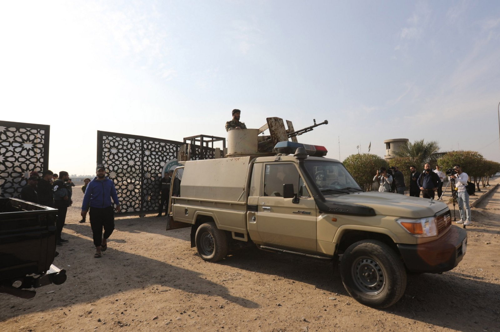 Members of Iraqi Shiite Popular Mobilization Forces (PMF) near a gate after a reported drone strike on a security headquarters in Baghdad, Iraq, Jan. 4, 2024. (EPA Photo)