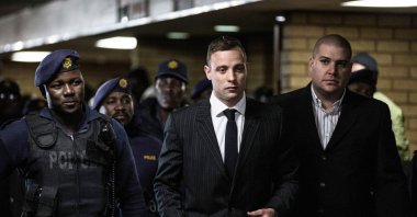 South African ex-Paralympian Oscar Pistorius (C) is surrounded by policemen as he arrives at Pretoria High Court to attend a sentencing hearing set to send him back to jail for murdering his girlfriend Reeva Steenkamp, Pretoria, South Africa, June 13, 2016. (AFP Photo)