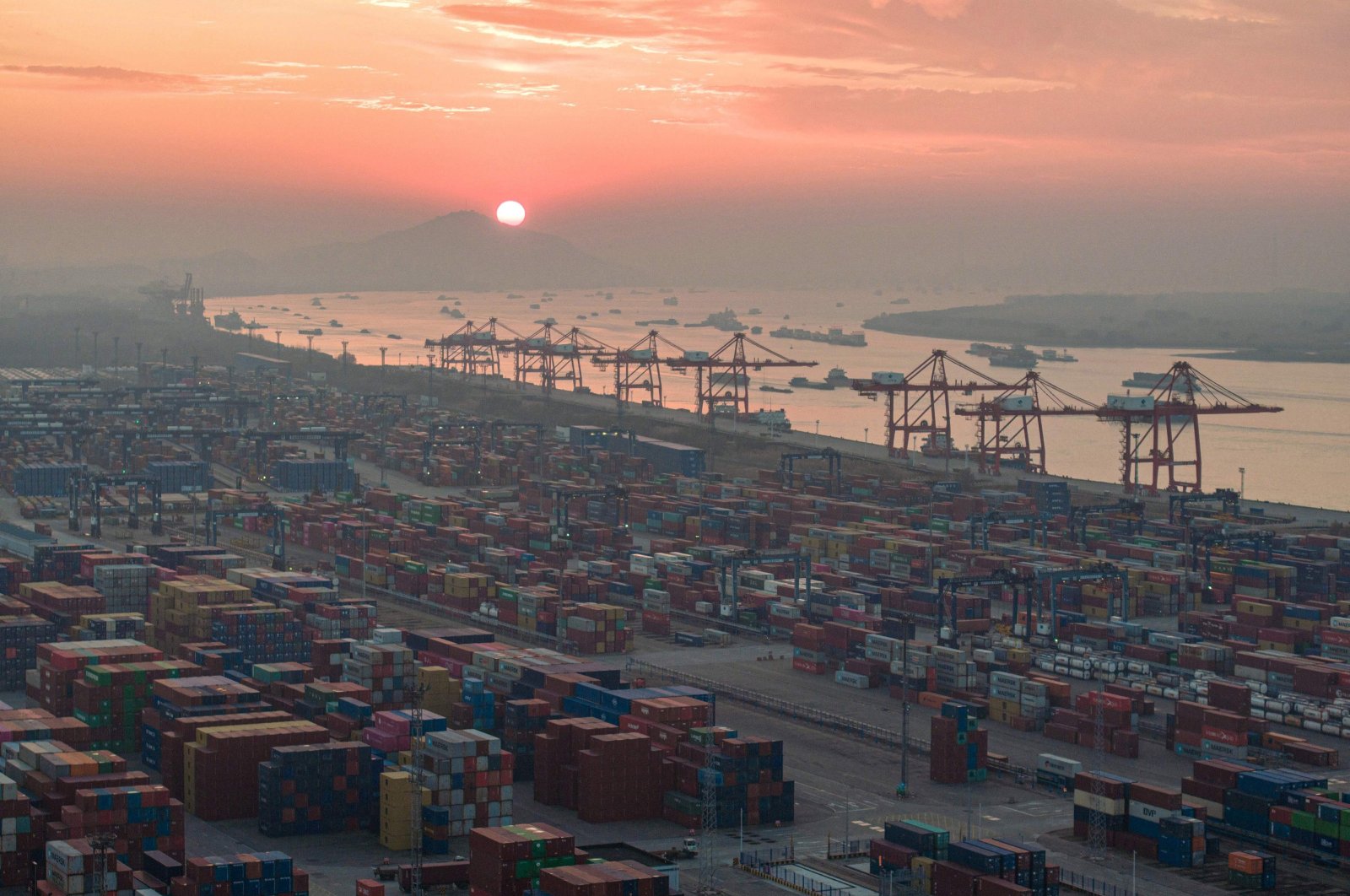 The aerial photo shows shipping containers stacked during the sunset at Nanjing port in China&#039;s eastern Jiangsu province, Jan. 4, 2024. (AFP Photo) 