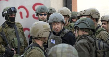 Israeli Prime Minister Benjamin Netanyahu (C) wears a protective vest and helmet as he receives a security briefing with commanders and soldiers in the northern Gaza Strip, Palestine, Dec. 25, 2023. (AP Photo)