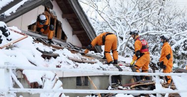 Emergency workers search for survivers in snow-covered ruins in the city of Suzu, Ishikawa prefecture, Jan. 8, 2024. (AFP Photo)