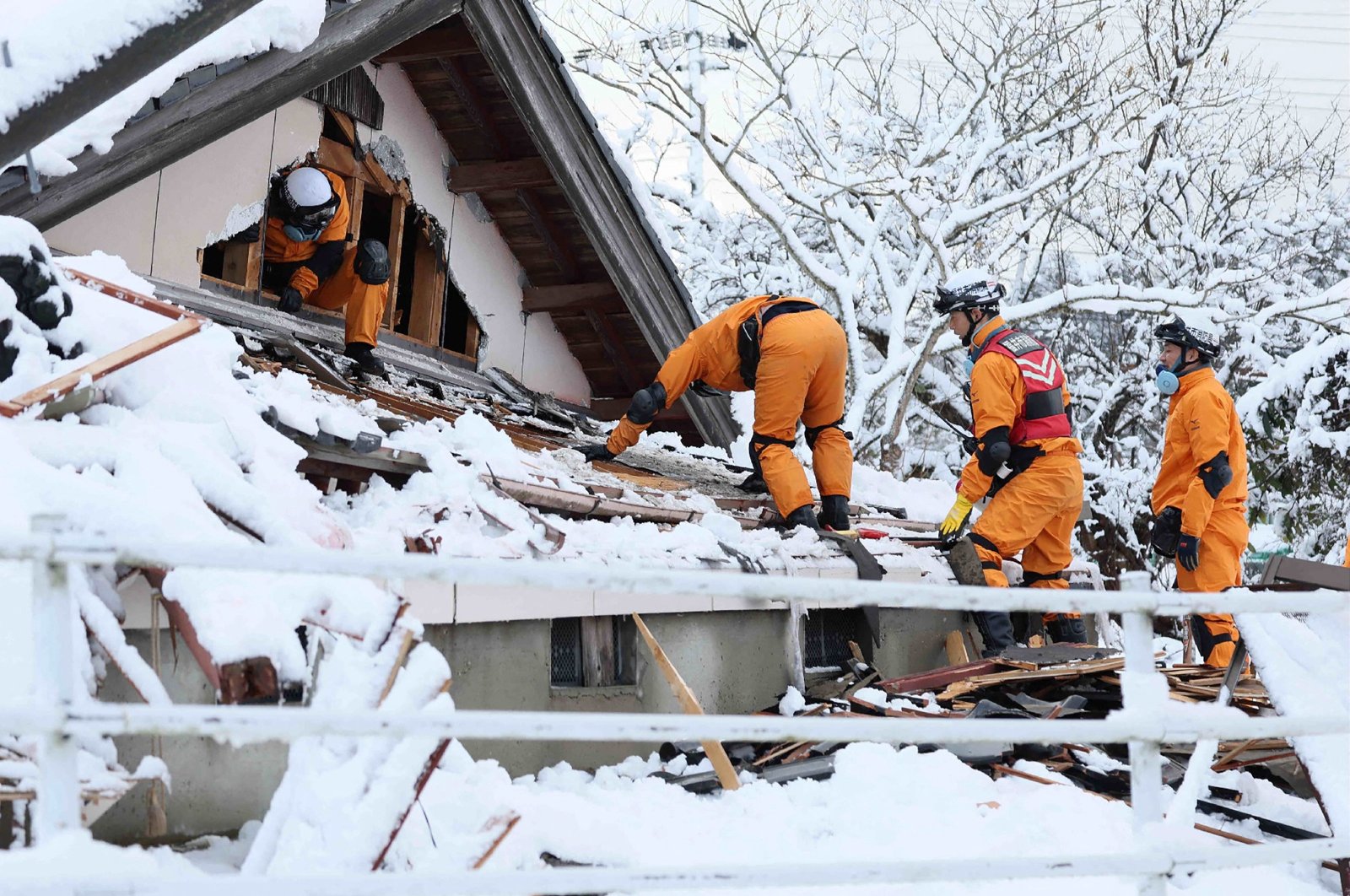 Emergency workers search for survivers in snow-covered ruins in the city of Suzu, Ishikawa prefecture, Jan. 8, 2024. (AFP Photo)