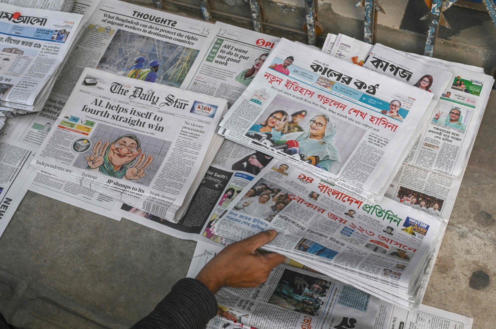 A vendor arranges newspapers with news of an election victory for the Awami League led by Prime Minister Sheikh Hasina, Dhaka, Bangladesh, Jan. 8, 2024. (AFP Photo)