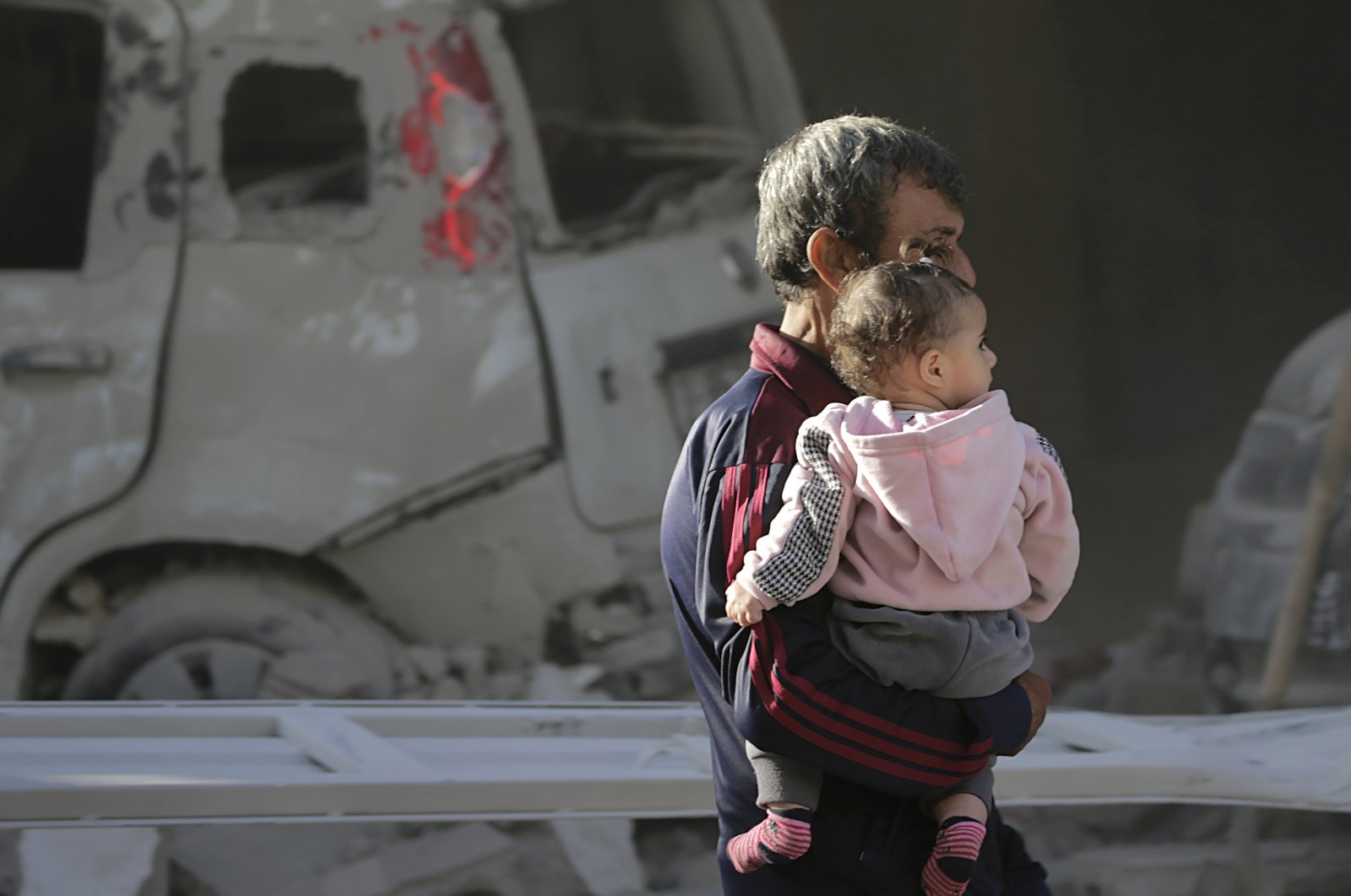 A Palestinian carrying his daughter, walks next to the rubble in a destroyed area following an Israeli airstrike in Deir Al-Balah, southern Gaza Strip, Palestine, Jan. 7, 2024. (EPA Photo)