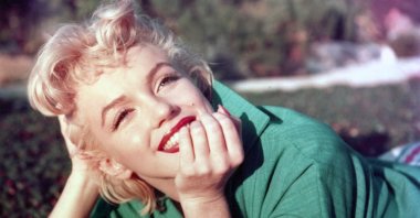 American actor Marilyn Monroe poses for a portrait laying on the grass in 1954 in Palm Springs, California. (Getty Images Photo)