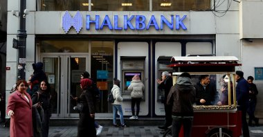 People walk past by a branch of Halkbank in central Istanbul, Türkiye, Jan. 22, 2020.