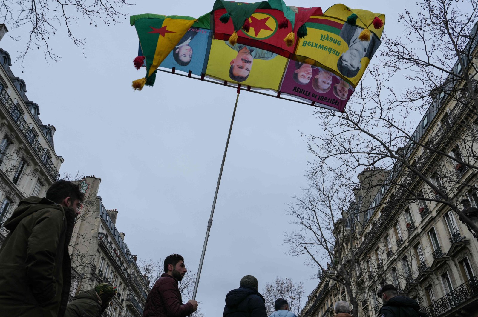 A man holds a banner with an image of Abdullah Öcalan, the jailed terrorist leader of the PKK, during a rally in Paris, France, Jan. 6, 2024. (AFP Photo)