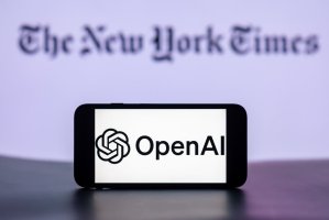 The OpenAI logo is seen displayed on a mobile phone screen with the New York Times Logo in the background. (Getty Images Photo)