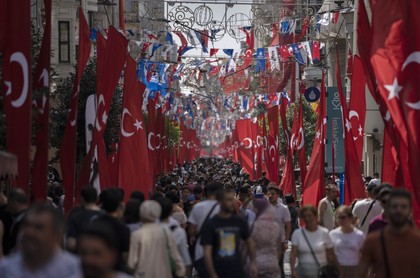 People walk in crowded Istiklal Street as it is decorated with Turkish flags marking Victory Day in Istanbul, Türkiye, Aug. 30, 2022. (AP Photo)