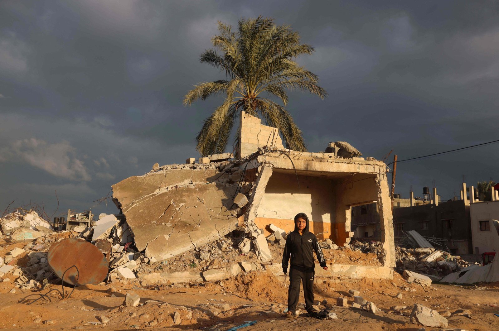 A Palestinian boy walks near a building destroyed in an Israeli airstrike, in Rafah, in the southern Gaza Strip, Palestine, Jan. 11, 2024. (AFP Photo)