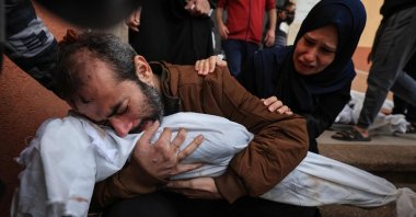 Jamil al-Agha and his wife react as the injured man holds the body of one of the couple's two children killed in Israeli bombardment, in Khan Yunis, southern Gaza Strip, Palestine, Nov. 19, 2023. (AFP File Photo)