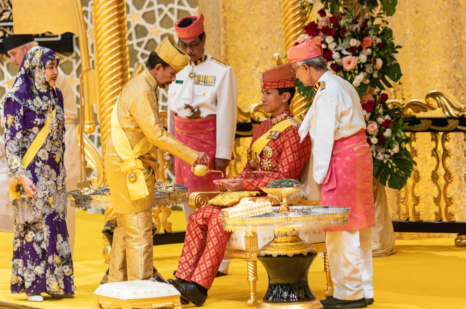 Brunei&#039;s Sultan Hassanal Bolkiah (2nd L) pouring scented oil on the hands of Prince Abdul Mateen during the royal powdering ceremony ahead of his wedding, Bandar Seri Begawan, Brunei, Jan. 10, 2024. (AFP Photo)