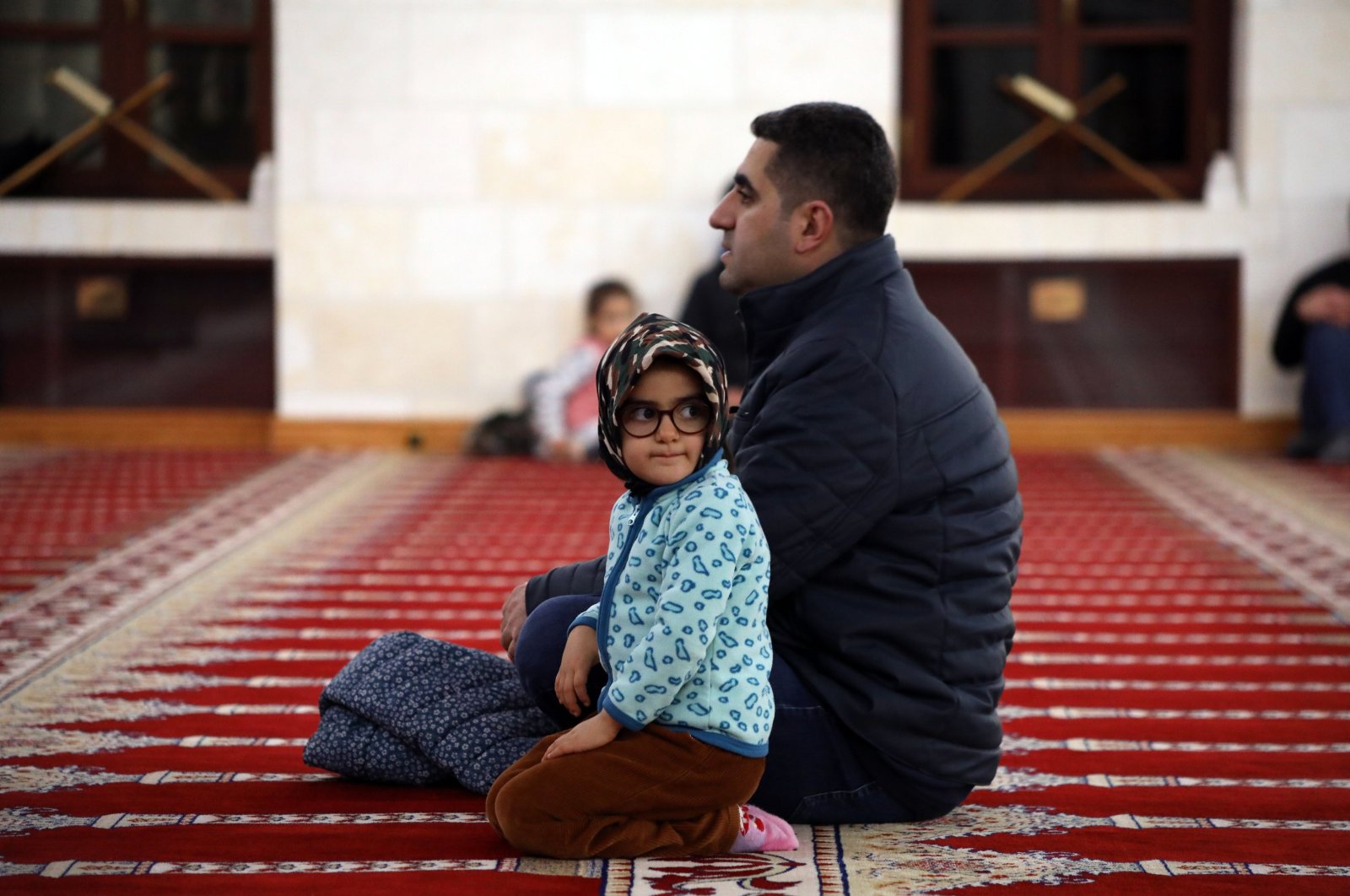 A child sits with her father in a mosque that was affected by the Feb. 6 earthquakes, Malatya, Türkiye, Jan. 12, 2024. (AA Photo)