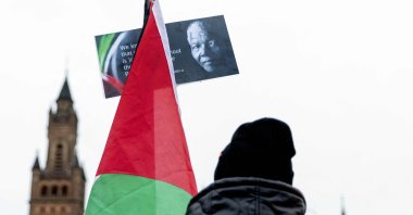 A Pro-Palestinian sympathizer holds a flag with an image of the late South African President Nelson Mandela as he takes part with others in a rally outside the International Court of Justice (ICJ) in The Hague, prior to the hearing of the genocide case against Israel, brought by South Africa, the Netherlands, Jan. 12, 2024. (AFP Photo)