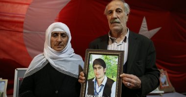 Yusuf Erdinç (R) and his wife pose with a picture of their son Mikail, who was abducted by PKK terrorists in 2015, during the sit-in protest in the Diyarbakır province, Türkiye, Jan. 13, 2024. (AA Photo)
