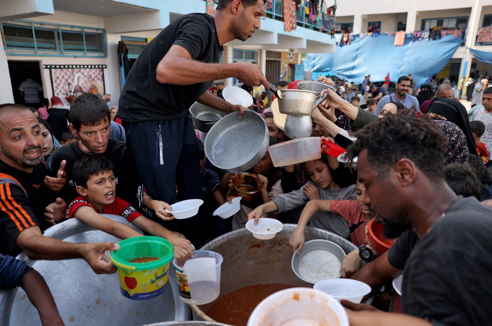 Palestinian children receive food at a U.N.-run school in Rafah, southern Gaza Strip, Palestine, Oct. 23, 2023. (AFP Photo)