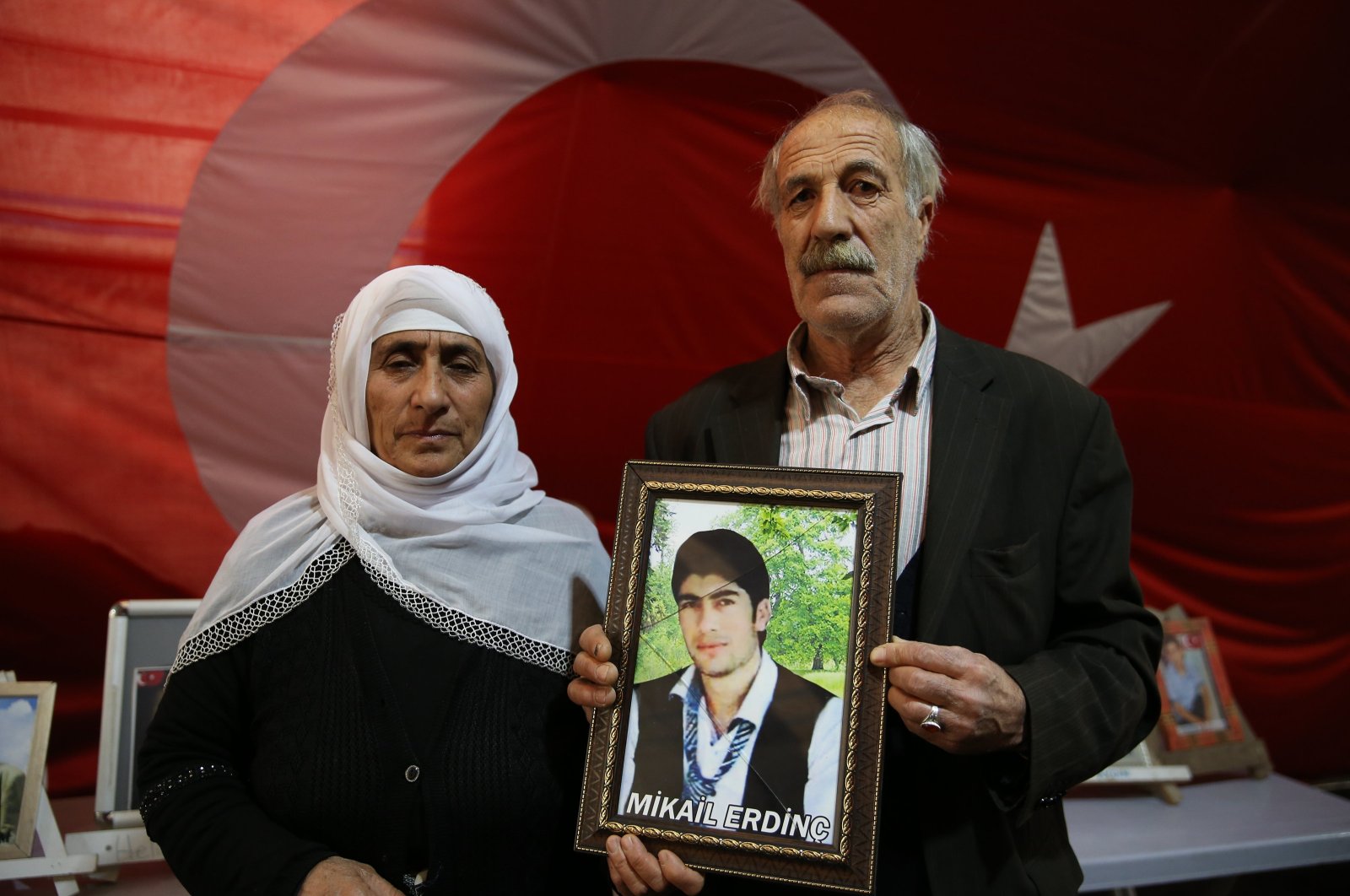 Yusuf Erdinç (R) and his wife pose with a picture of their son Mikail, who was abducted by PKK terrorists in 2015, during the sit-in protest in the Diyarbakır province, Türkiye, Jan. 13, 2024. (AA Photo)