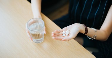 A woman holding pills in her hand. (Getty Images Photo)