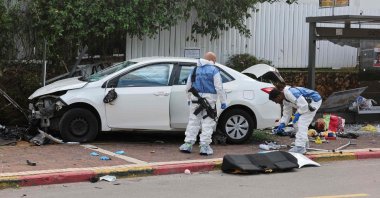 Israeli police forensics personnel inspect a damaged car in the central town of Raanana, Israel, Jan. 15, 2024. (AFP Photo)