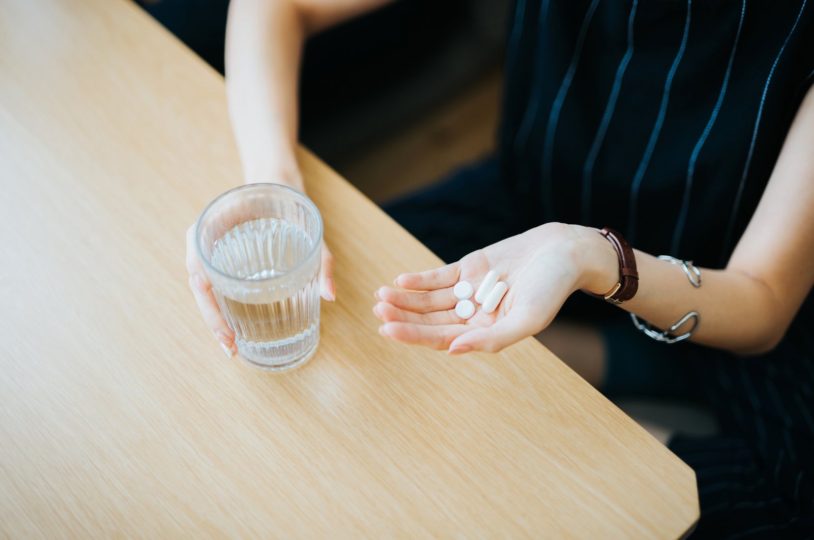 A woman holding pills in her hand. (Getty Images Photo)