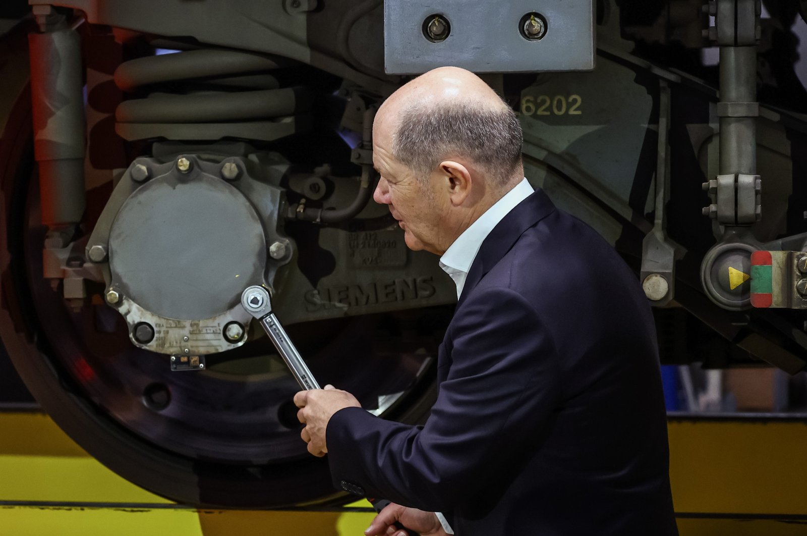 German Chancellor Olaf Scholz uses a tool during the opening ceremony of the new Deutsche Bahn ICE4 express train plant in Cottbus, Germany, Jan. 11, 2024. (EPA Photo)