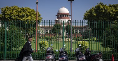 A lawyer walks in front of the Supreme Court premises, New Delhi, India, Oct. 13, 2022. (AP Photo)