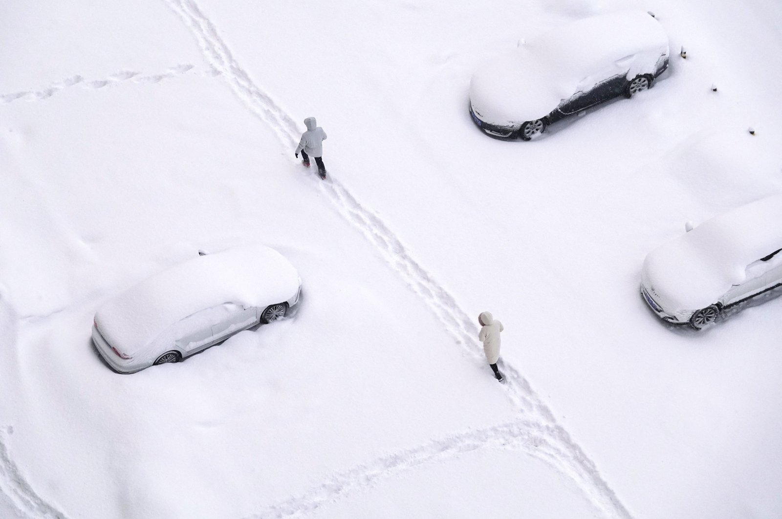 People walking on a snow-covered street during snowfall in Yantai, in China’s eastern Shandong province, Dec. 21, 2023. (AFP Photo)
