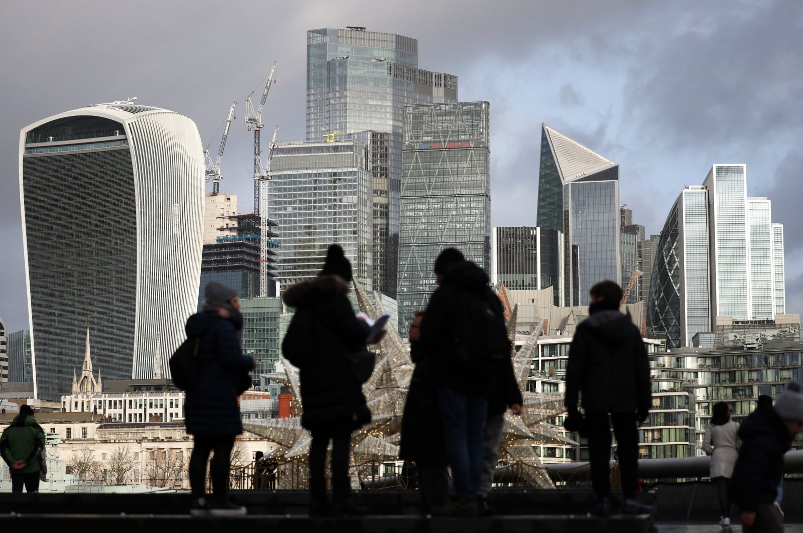 People are silhouetted against the City of London, London, Britain, Dec. 28, 2023. (EPA Photo)