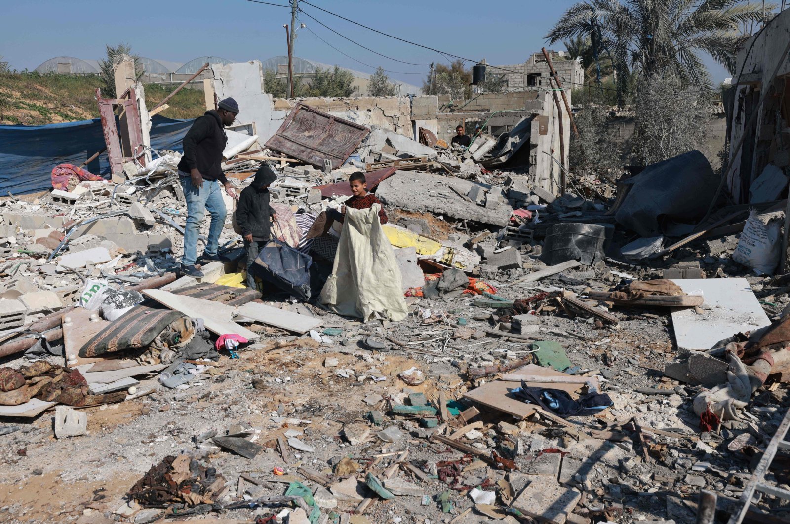 Palestinian children look for salvageable items amid Israel's destruction on the southern outskirts of Khan Younis in the war-battered Gaza Strip on Jan. 16, 2024. (AFP Photo)