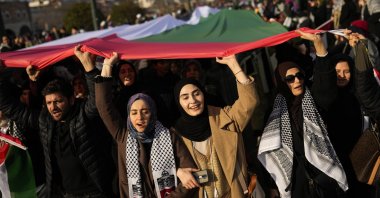 People hold up a giant Palestinian flag as they demonstrate at the Galata bridge landmark to show solidarity with Palestinians amid the ongoing war in Gaza, Istanbul, Türkiye, Jan. 1, 2024. (AP Photo)