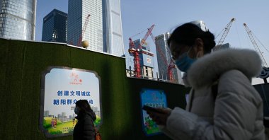 People walk past a construction site at the Central Business District (CBD) in Beijing, China, Jan. 16, 2024. (AFP Photo)