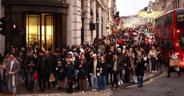 Shoppers wait to cross a side road beside shops on Regent Street in London, U.K., Dec. 22, 2023. (AFP Photo)