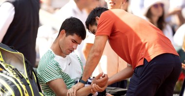 An injured Carlos Alcaraz receives treatment during his loss against Novak Djokovic in the semifinal of the singles competition on Court Philippe Chatrier during the 2023 French Open Tennis Tournament at Roland Garros, Paris, France, June 9, 2023. (Getty Images Photo)
