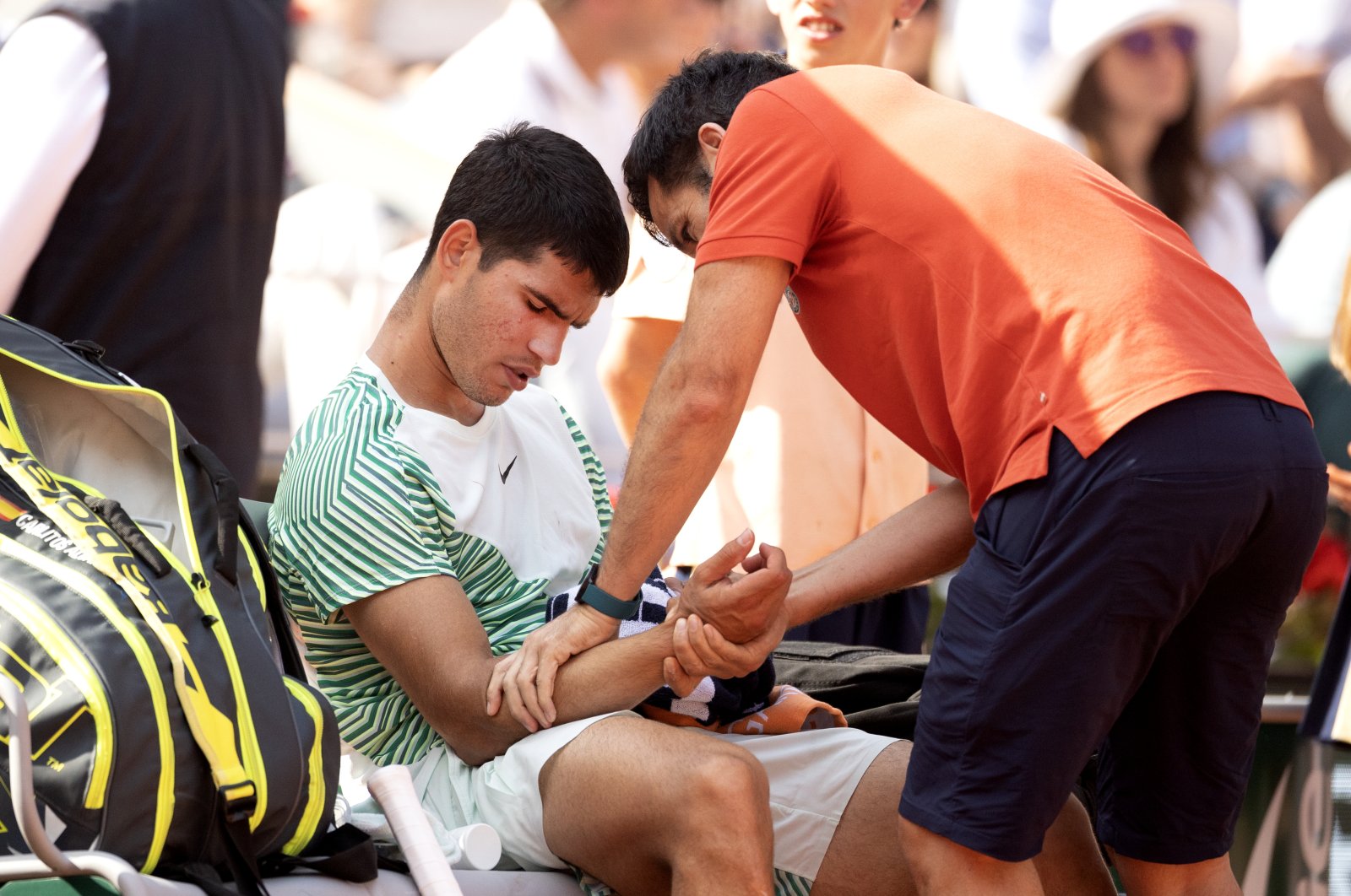 An injured Carlos Alcaraz receives treatment during his loss against Novak Djokovic in the semifinal of the singles competition on Court Philippe Chatrier during the 2023 French Open Tennis Tournament at Roland Garros, Paris, France, June 9, 2023. (Getty Images Photo)