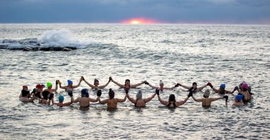 A group consisting mostly of women, who call themselves "The Endorphins," gather for a sunrise swim in the chilly waters of Lake Ontario during freezing temperatures in Toronto, Ontario, Canada. Jan. 17, 2024.  (Reuters Photo)