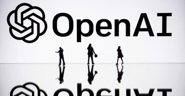 This illustration photograph shows figurines next to a screen displaying a logo of OpenAI, a US artificial intelligence organization, Mulhouse, eastern France, Oct. 30, 2023. (AFP Photo)