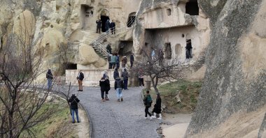 Visitors walk on the path close to carved rock formations typical for the Cappadocia region, Nevşehir, central Türkiye, Jan. 3, 2024. (AA Photo)