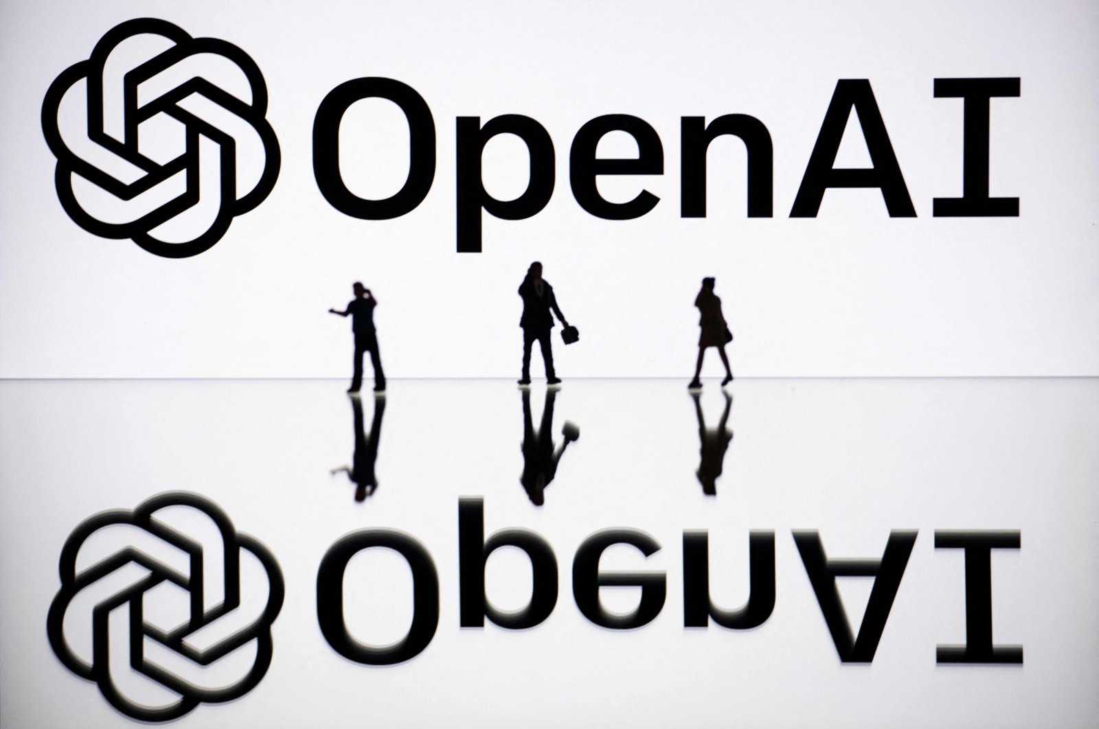 This illustration photograph shows figurines next to a screen displaying a logo of OpenAI, a US artificial intelligence organization, Mulhouse, eastern France, Oct. 30, 2023. (AFP Photo)