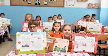 Children are seen happy holding their report cards for the academic year, Istanbul, Türkiye, Jan. 19, 2024. (IHA Photo)