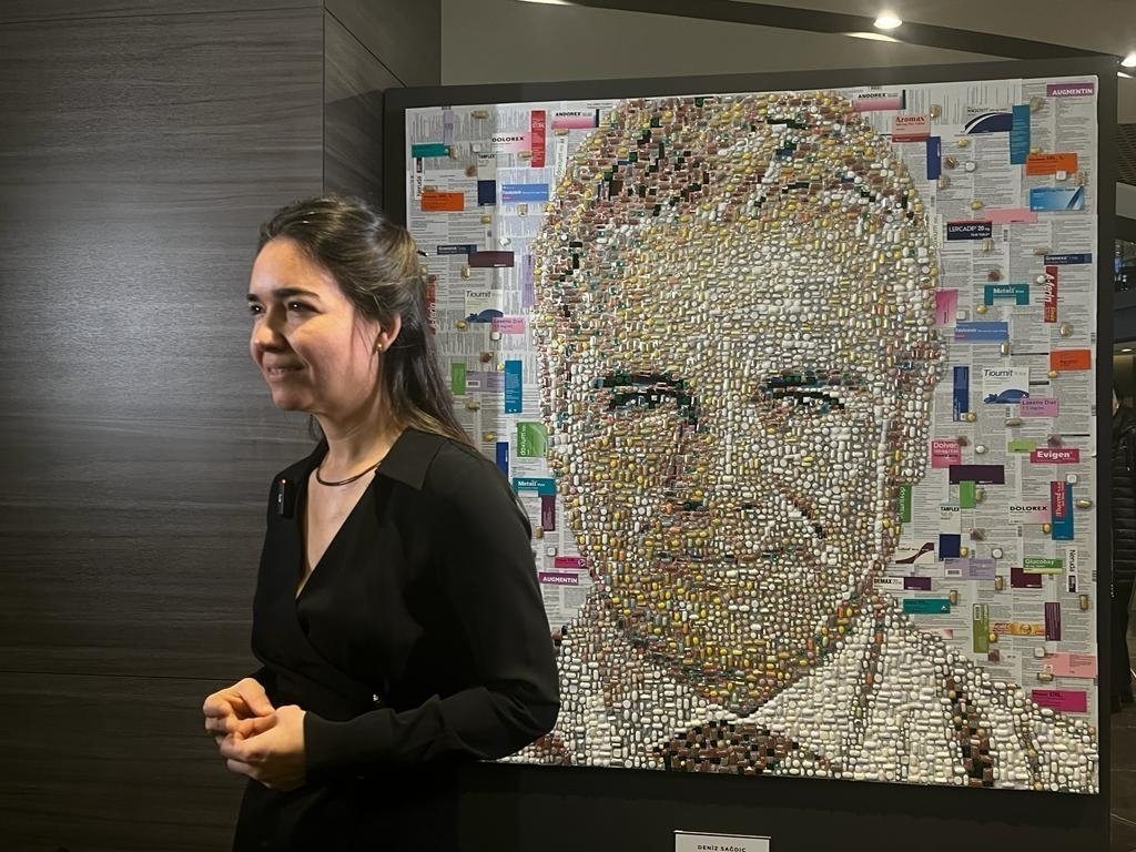 Deniz Sağdıç gives an interview in front of the portrait she created from discarded pill and medicine boxes, Istanbul, Türkiye, Jan. 11, 2024. (Photo by Betül Tilmaç)