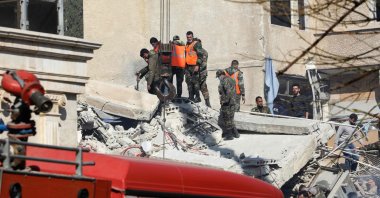 Syrian emergency workers search the rubble of a building destroyed in an Israeli airstrike, Damascus, Syrian, Jan. 20, 2024. (AFP Photo)