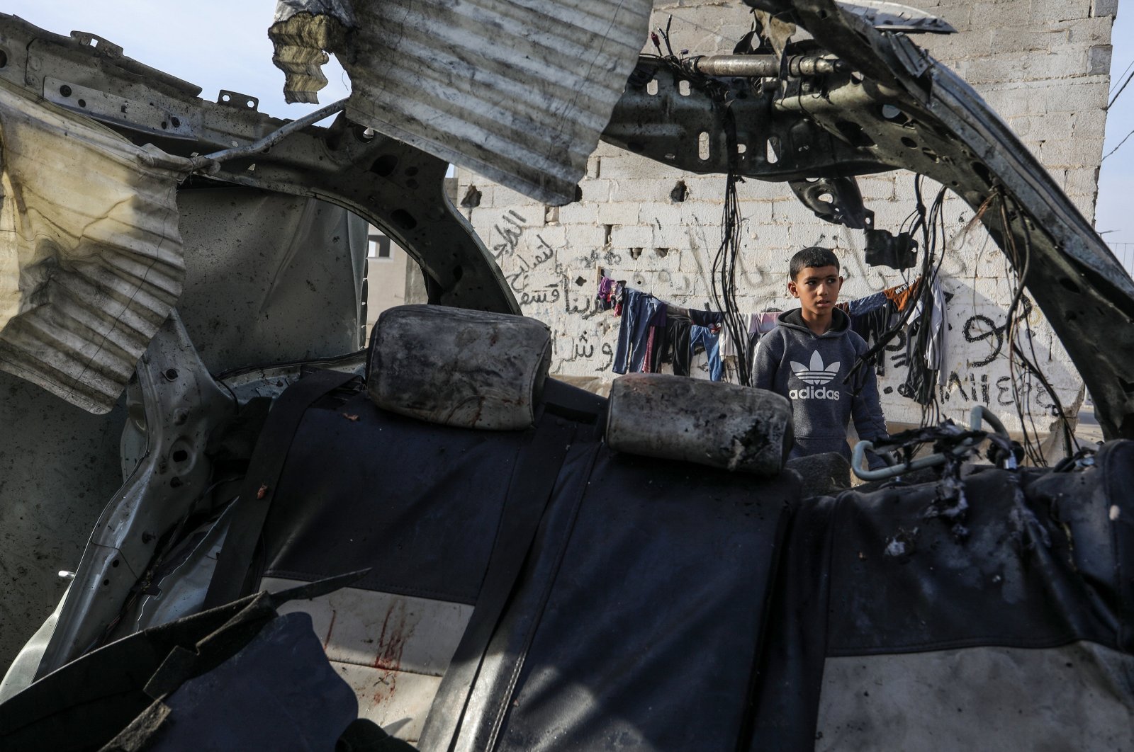 A Palestinian child looks at a car destroyed in an Israeli attack on Rafah, southern Gaza, Palestine, Jan. 22, 2024. (AA Photo)