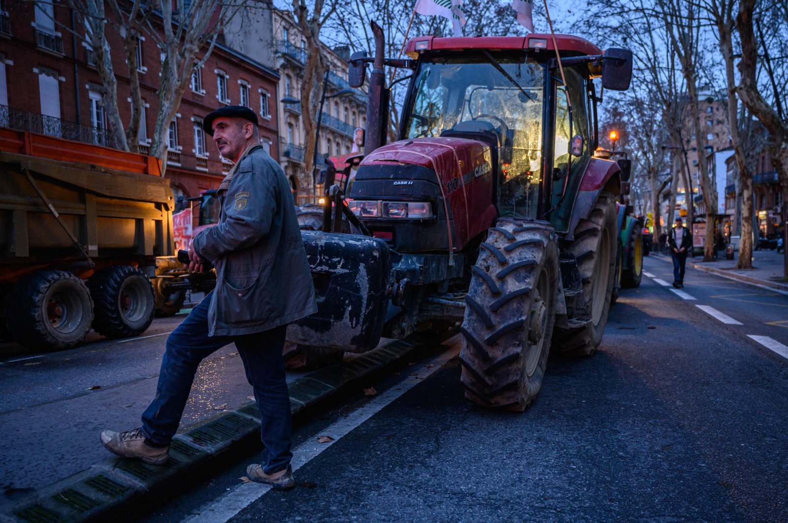 A farmer from the Midi-Pyrenees area of southwestern France prepares to leave with others in their tractors after a protest against taxation and declining income, in central Toulouse, France, Jan. 16, 2024. (AFP Photo)