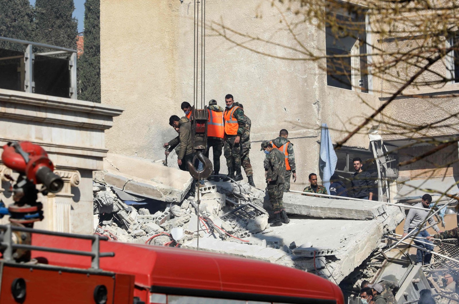 Syrian emergency workers search the rubble of a building destroyed in an Israeli airstrike, Damascus, Syrian, Jan. 20, 2024. (AFP Photo)