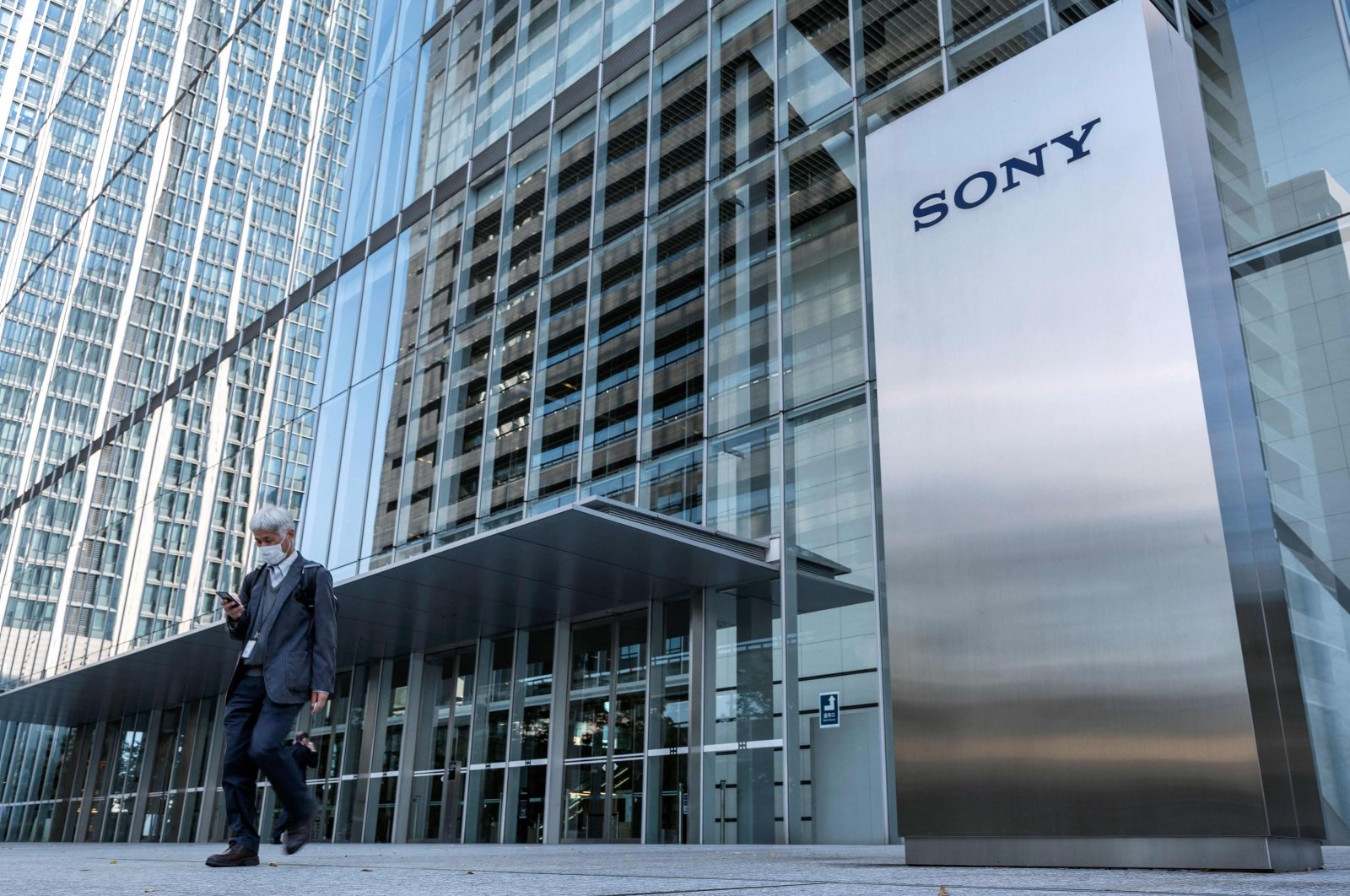 This file photo shows a man walking past the Sony logo outside the company&#039;s headquarters in Tokyo, Japan, Oct. 31, 2022. (AFP Photo)