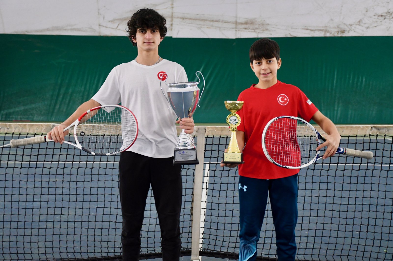 Turkish tennis players Emirhan Bulut (L) and his brother Talha Emin Bulut pose for a photo with their trophies at the Darıca Tennis Club, Kocaeli, Türkiye, Jan. 14, 2024. (AA Photo)