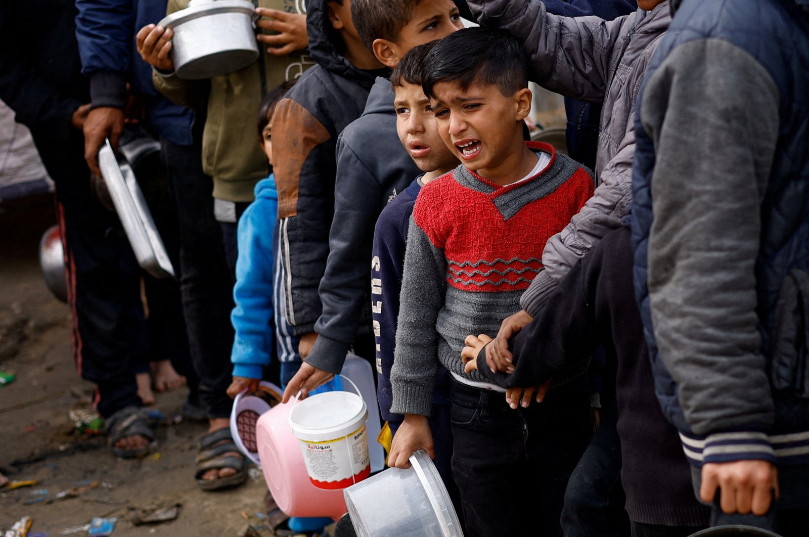 A boy reacts as Palestinians wait to receive food amid shortages of food supplies, in Rafah in the southern Gaza Strip Jan. 17, 2024. (Reuters File Photo)