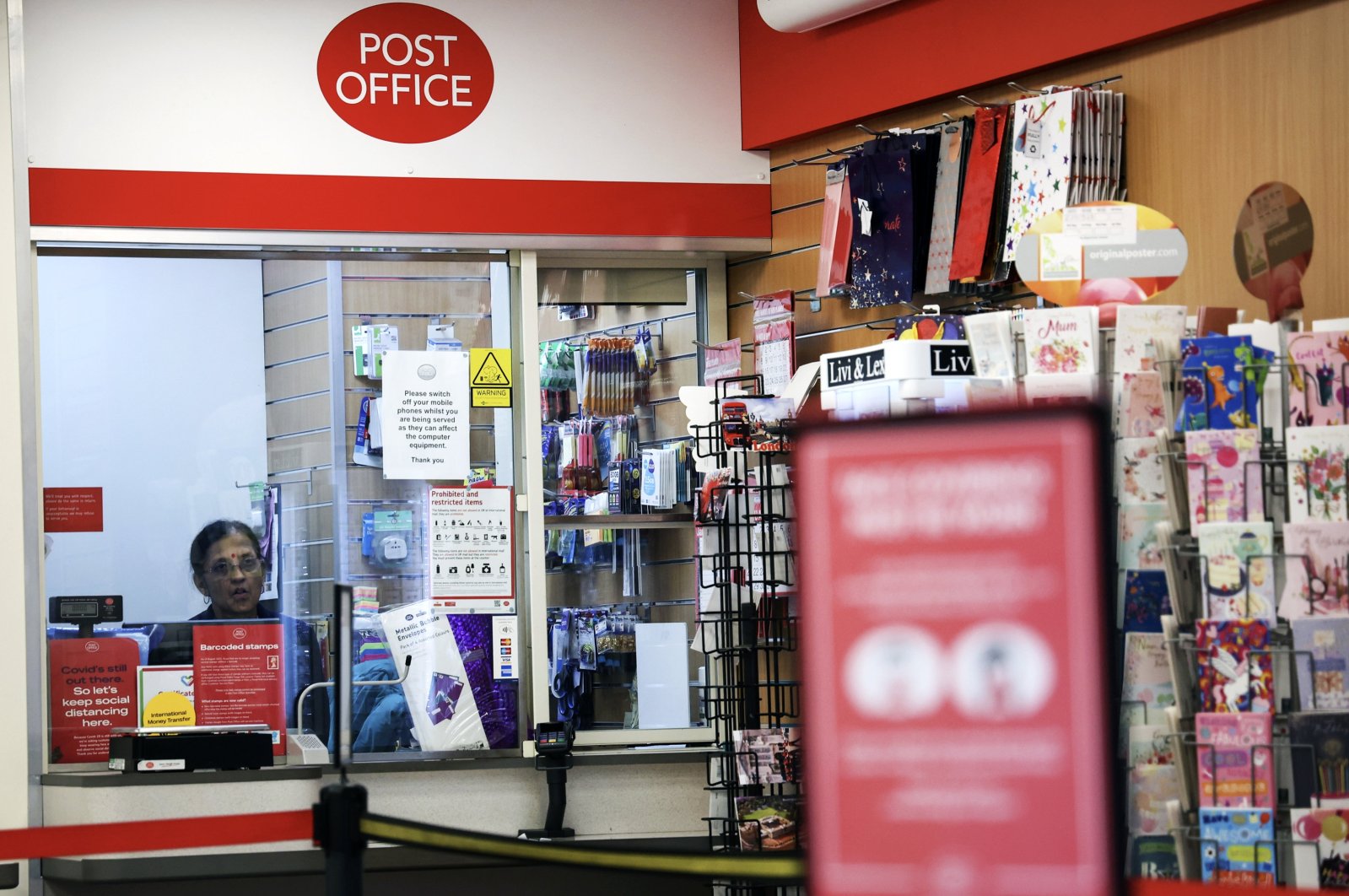 An employee sits inside a Post Office branch in London, Britain, Jan. 10, 2024. (EPA Photo)