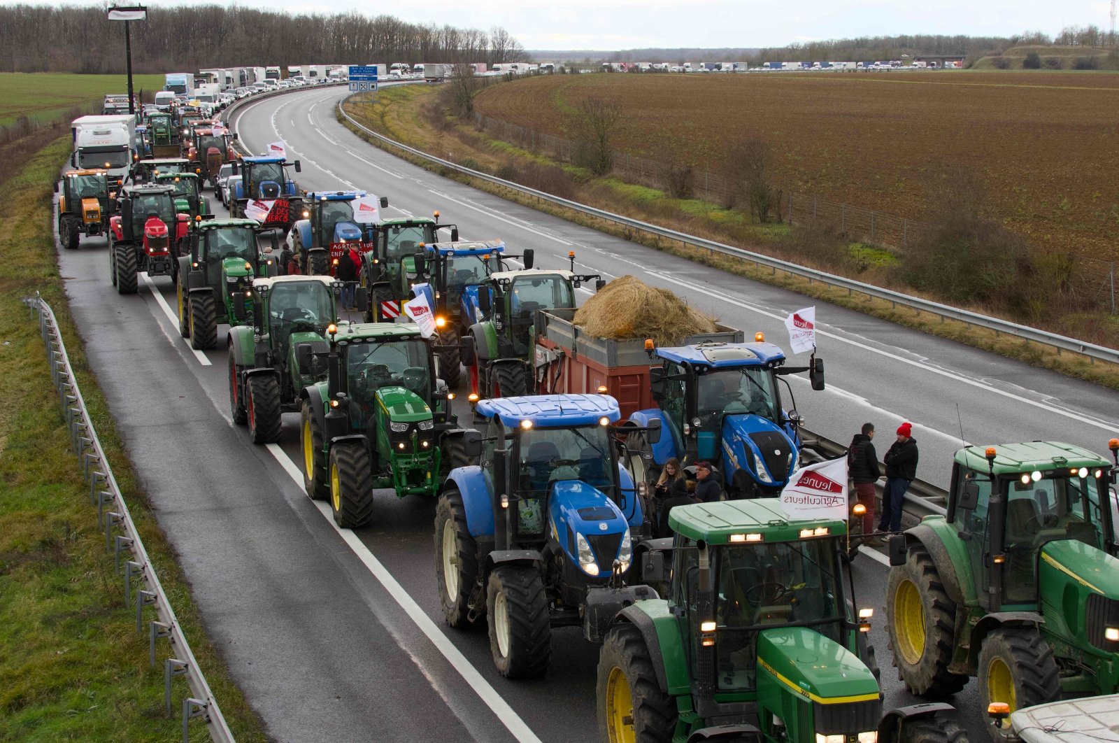 French farmers drive their tractors to disrupt traffic on the A71 highway to protest taxation and declining income, Levet near Bourges, France, Jan. 24, 2024. (AFP Photo)